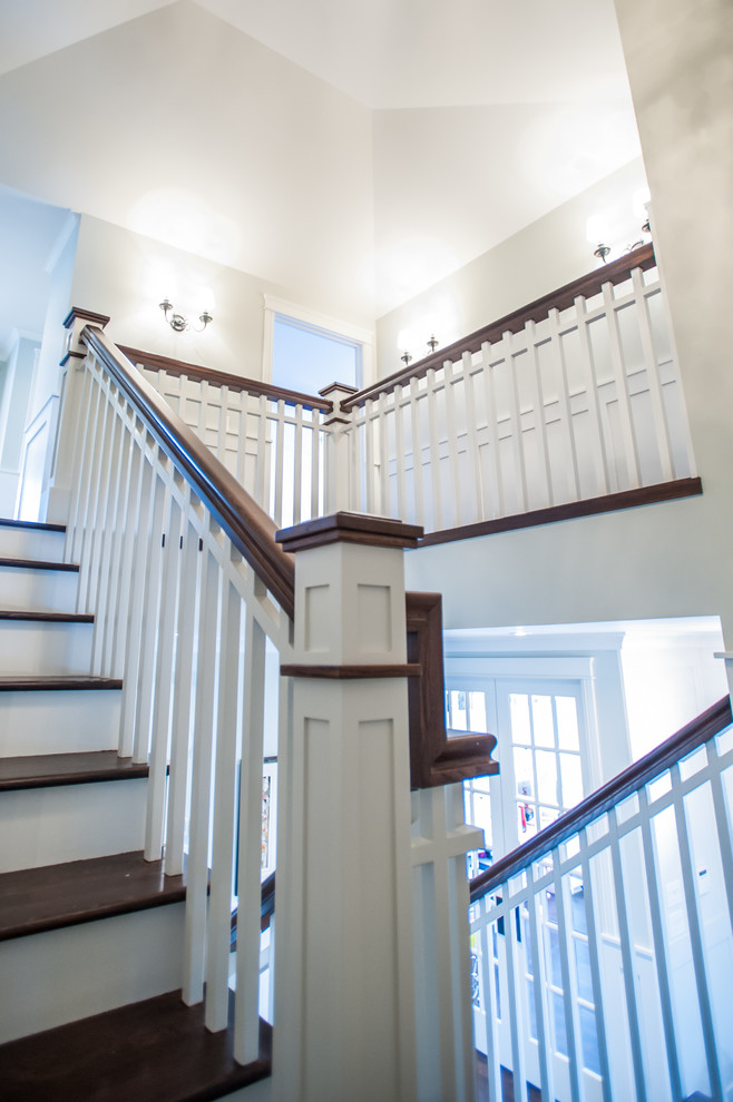 This is an example of a large traditional wood u-shaped staircase in Calgary with painted wood risers.
