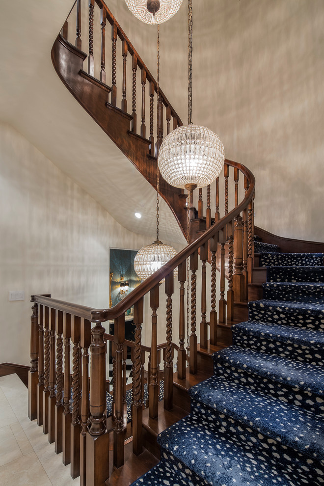 Стильный дизайн: большая изогнутая деревянная лестница в классическом стиле с ступенями с ковровым покрытием - последний тренд