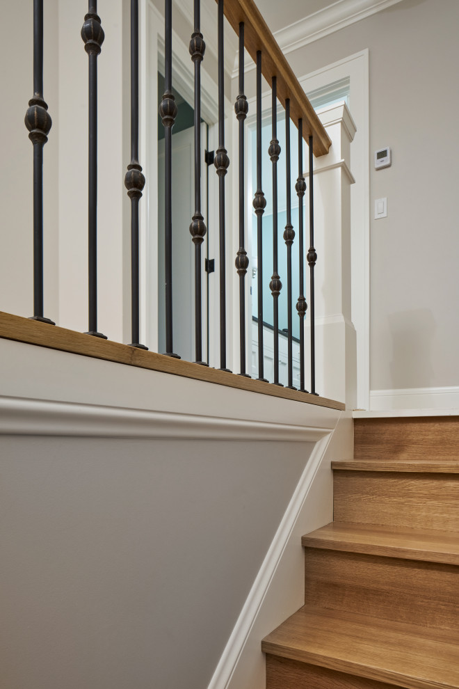 Diseño de escalera recta de estilo americano de tamaño medio con escalones de madera, contrahuellas de madera y barandilla de madera