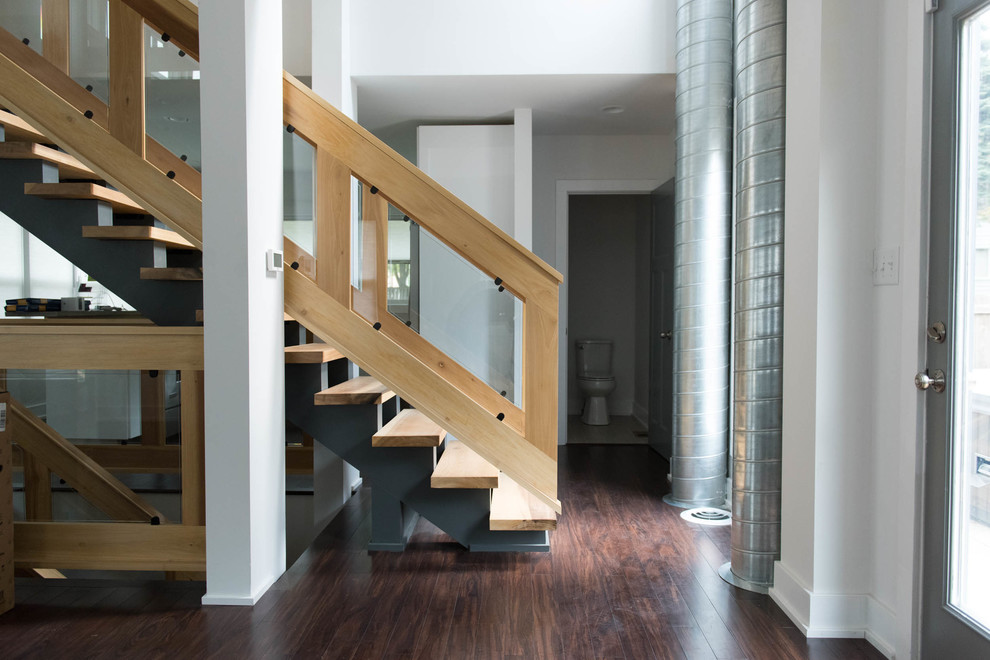 Large contemporary wood straight wood railing staircase in Indianapolis with metal risers.