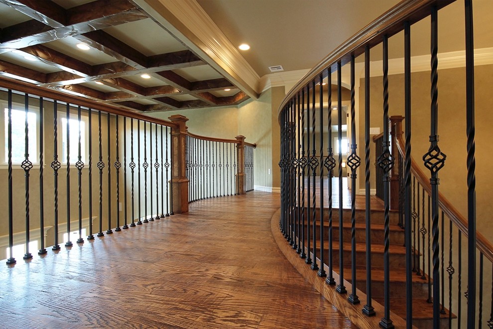 This is an example of a large traditional wood curved staircase in Other with wood risers.