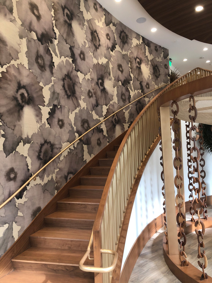 Свежая идея для дизайна: изогнутая лестница в стиле модернизм с деревянными перилами и обоями на стенах - отличное фото интерьера