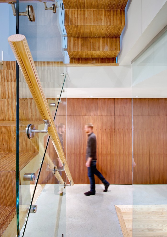 トロントにある高級な中くらいなコンテンポラリースタイルのおしゃれなかね折れ階段 (木の蹴込み板、木材の手すり) の写真