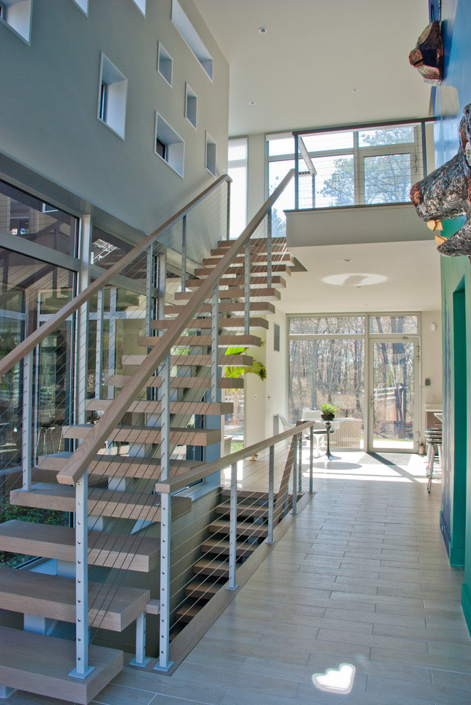 Cette photo montre un grand escalier sans contremarche droit tendance avec des marches en bois.