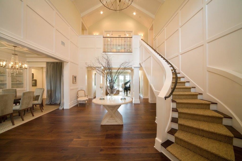 This is an example of a large traditional wood curved wood railing staircase in Orlando with painted wood risers.