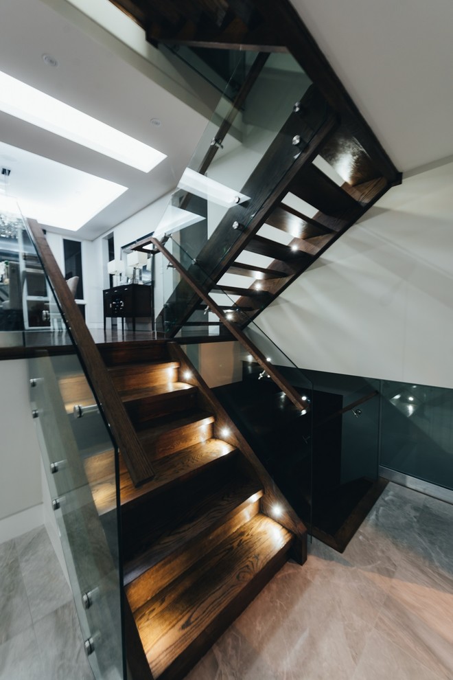 Example of a huge minimalist wooden floating glass railing and open staircase design in Toronto