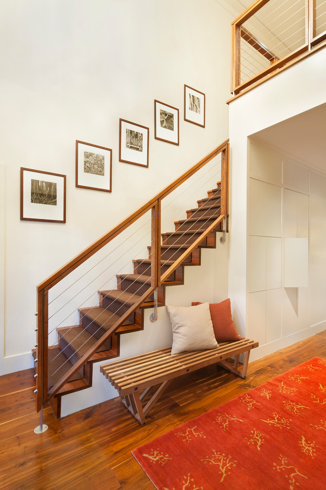 Exemple d'un escalier droit tendance de taille moyenne avec des marches en bois, des contremarches en bois et un garde-corps en câble.