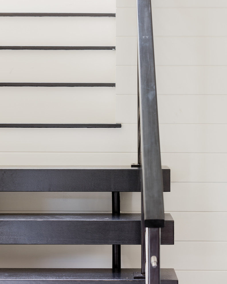 Immagine di una scala a rampa dritta design di medie dimensioni con pedata in legno e alzata in legno verniciato