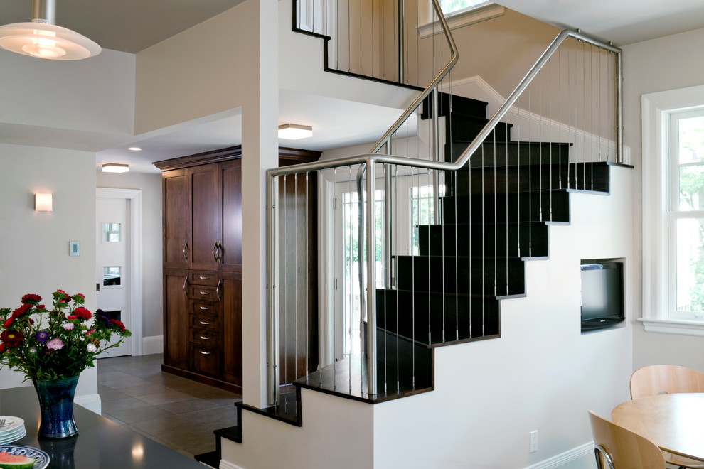 Réalisation d'un escalier design en L de taille moyenne avec des marches en bois, des contremarches en bois et un garde-corps en câble.
