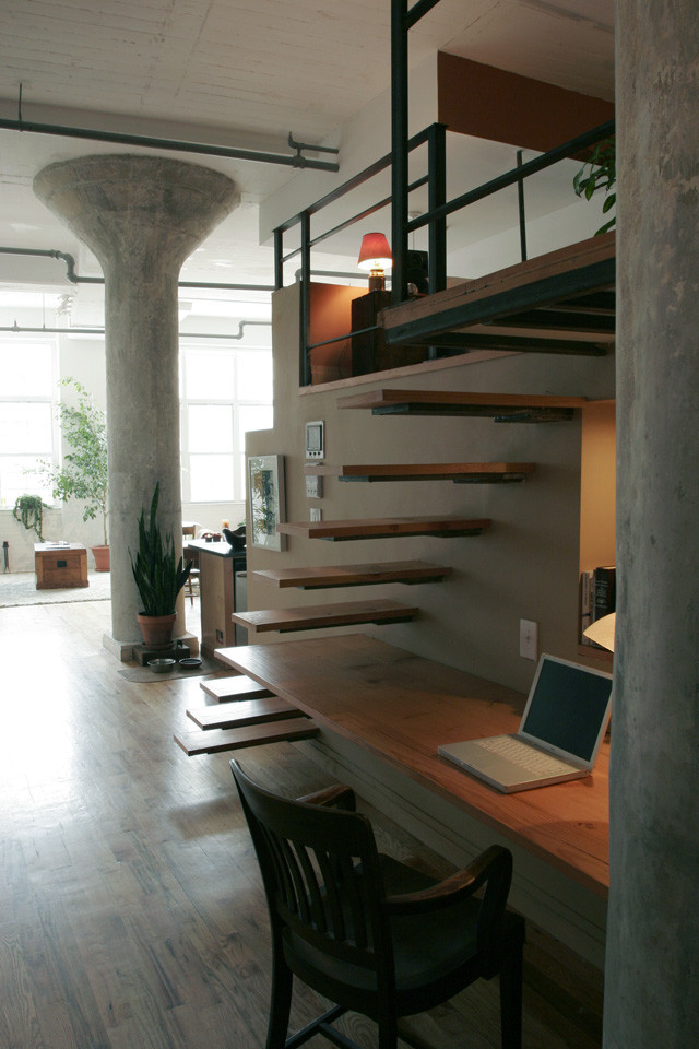 Cette image montre un escalier design avec des marches en bois et un garde-corps en matériaux mixtes.