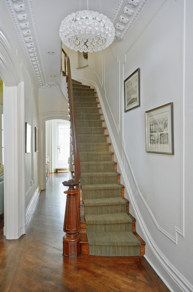 Staircase - transitional wooden curved staircase idea in New York with wooden risers