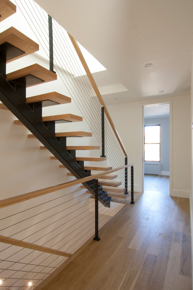 Inspiration pour un escalier sans contremarche flottant design de taille moyenne avec des marches en bois et un garde-corps en câble.