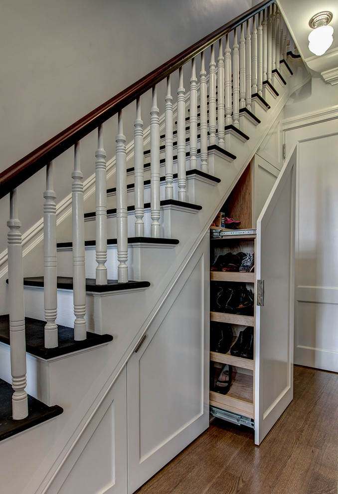 Classic wood staircase in New York with under stair storage and feature lighting.