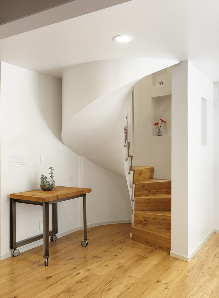 Design ideas for a small retro wood spiral staircase in New York with wood risers and feature lighting.