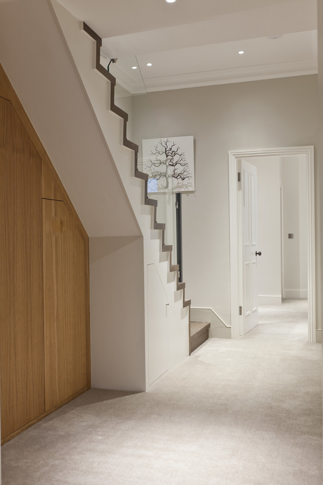 Inspiration for a medium sized contemporary wood straight glass railing staircase in London with wood risers.