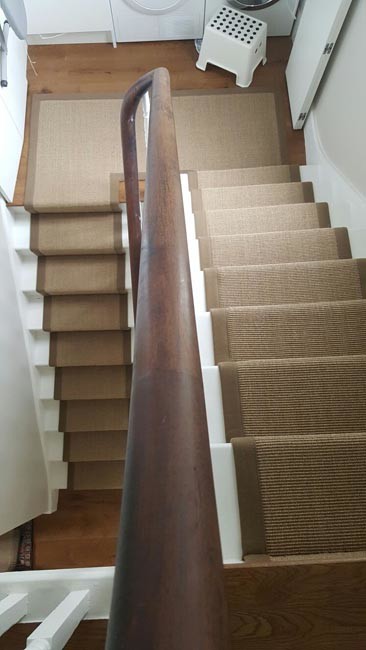Exempel på en mellanstor klassisk u-trappa, med heltäckningsmatta, sättsteg med heltäckningsmatta och räcke i trä