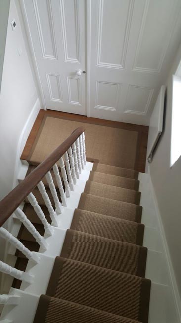 Medium sized traditional carpeted u-shaped wood railing staircase in London with carpeted risers.