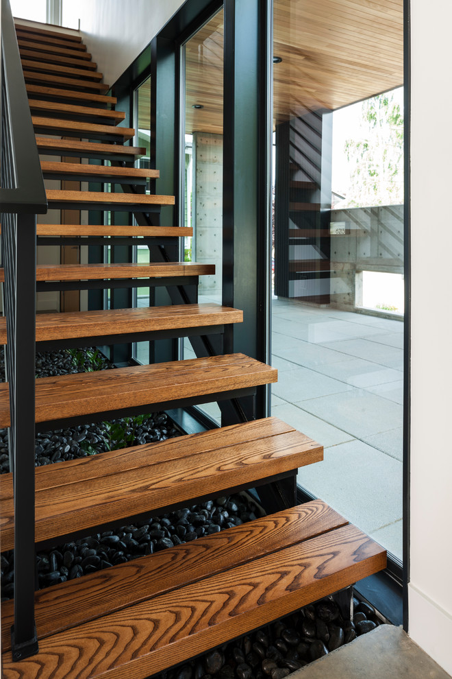 Inspiration för mellanstora moderna flytande trappor i trä, med öppna sättsteg och räcke i metall