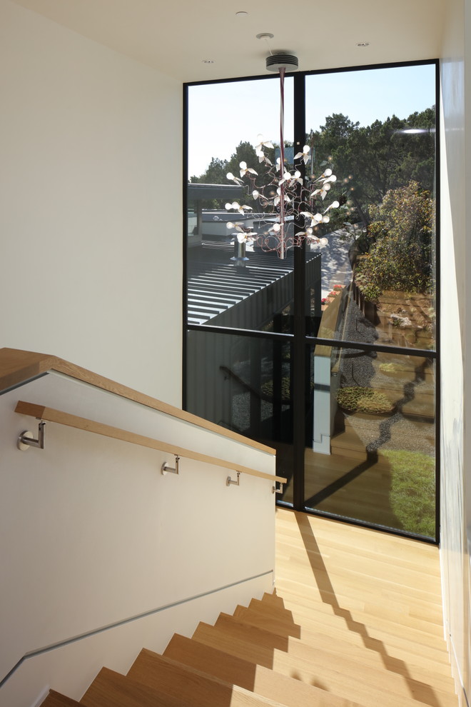 Diseño de escalera en U contemporánea grande con escalones de madera, contrahuellas de madera y barandilla de madera