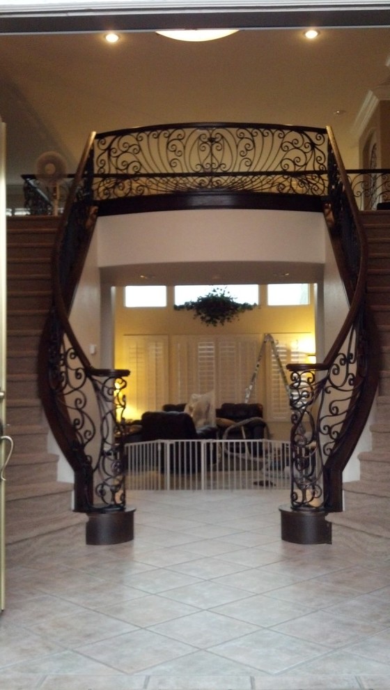 Aménagement d'un grand escalier courbe classique avec des marches en bois et des contremarches en bois.