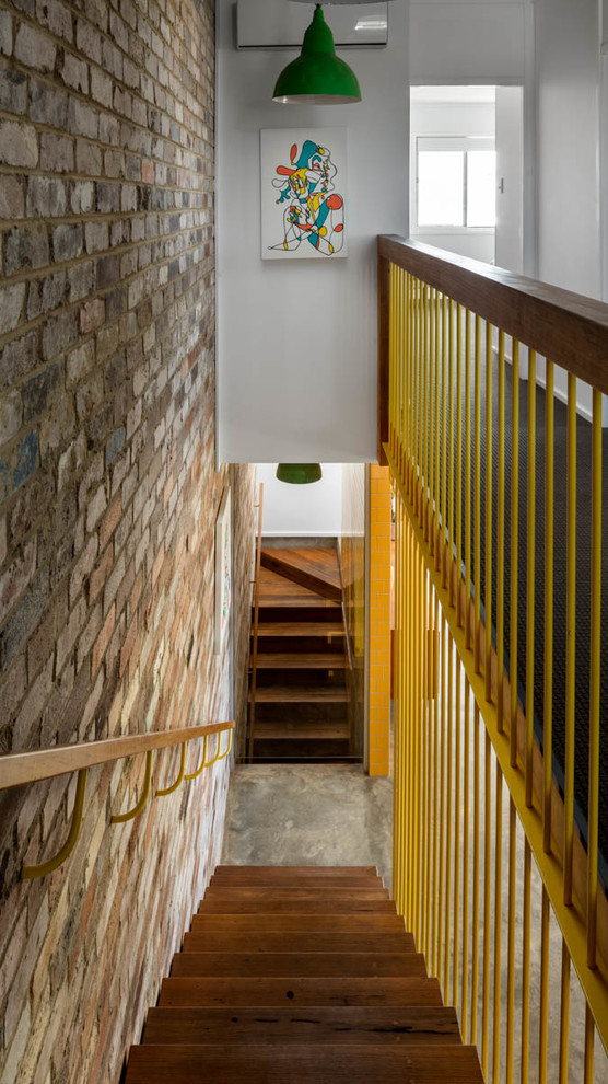 Cette image montre un escalier sans contremarche urbain avec des marches en bois et un garde-corps en métal.