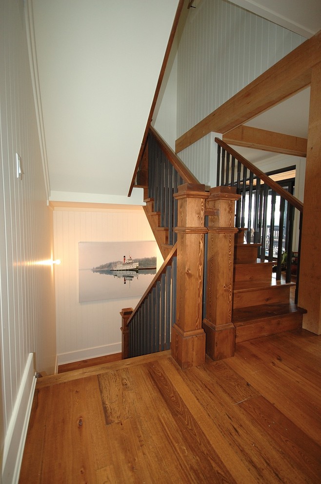 На фото: угловая лестница среднего размера в стиле рустика с металлическими ступенями и деревянными перилами с