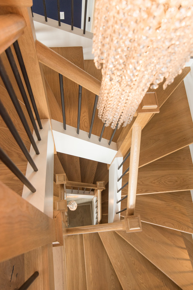 На фото: деревянная лестница на больцах, среднего размера в стиле неоклассика (современная классика) с деревянными ступенями с