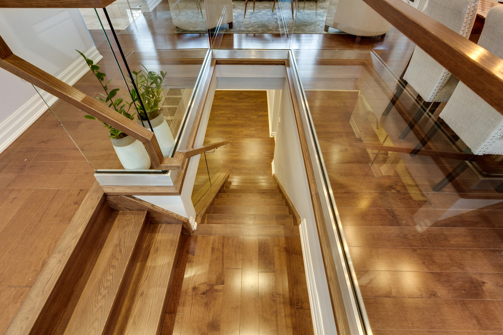 Imagen de escalera en L actual de tamaño medio con escalones de madera, contrahuellas de madera y barandilla de madera