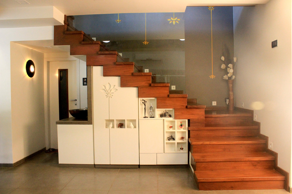 This is an example of a contemporary staircase in Mumbai with under stair storage.