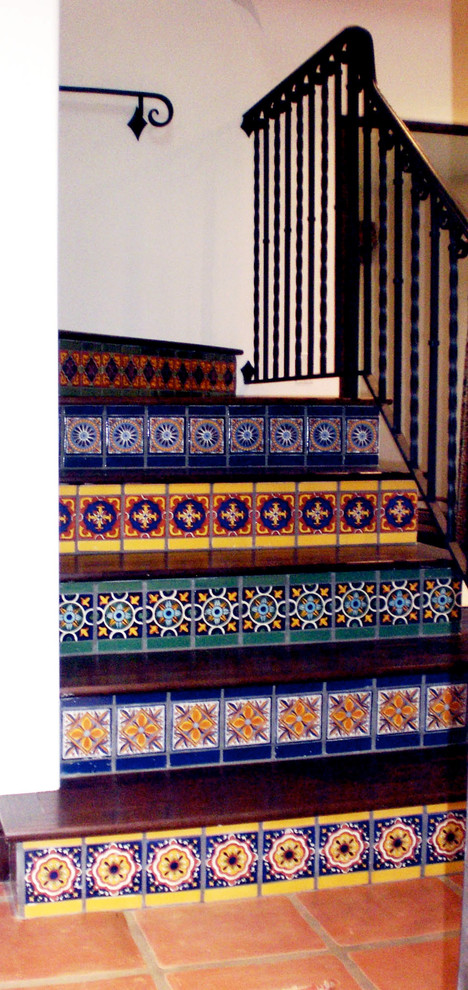 Diseño de escalera en L mediterránea de tamaño medio con escalones de madera y contrahuellas con baldosas y/o azulejos