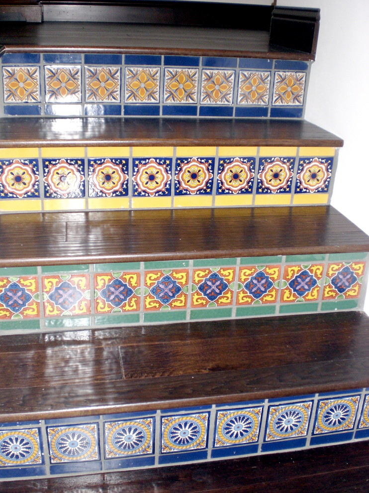 This is an example of a medium sized mediterranean wood l-shaped staircase in Santa Barbara with tiled risers.