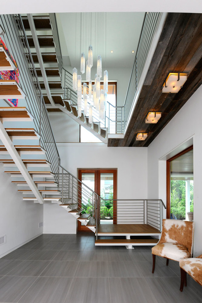На фото: угловая лестница в морском стиле с деревянными ступенями без подступенок с