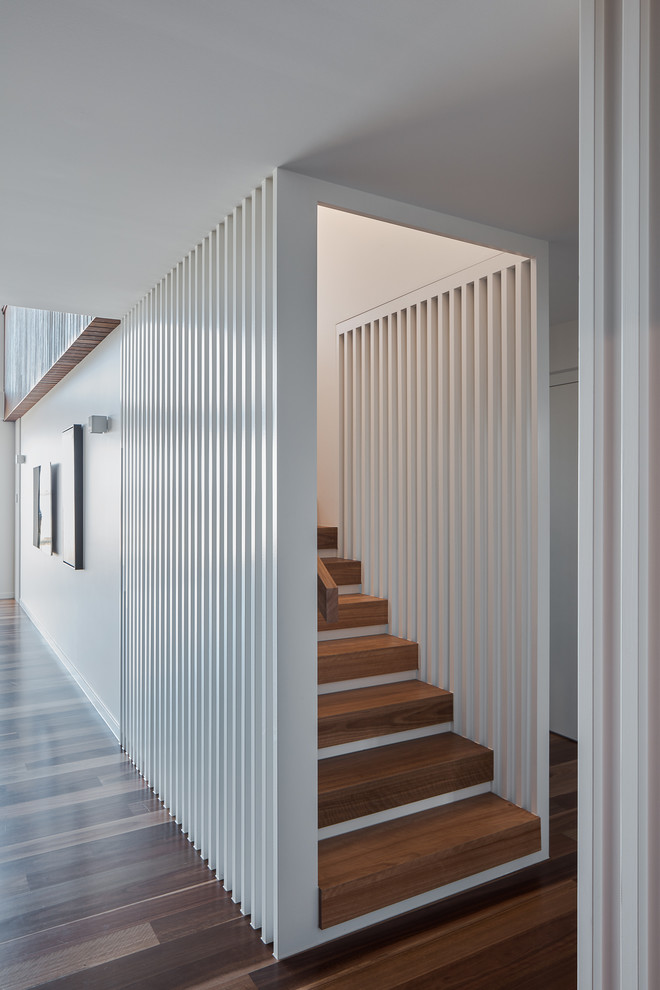 Inspiration pour un escalier peint droit minimaliste de taille moyenne avec des marches en bois et un garde-corps en bois.