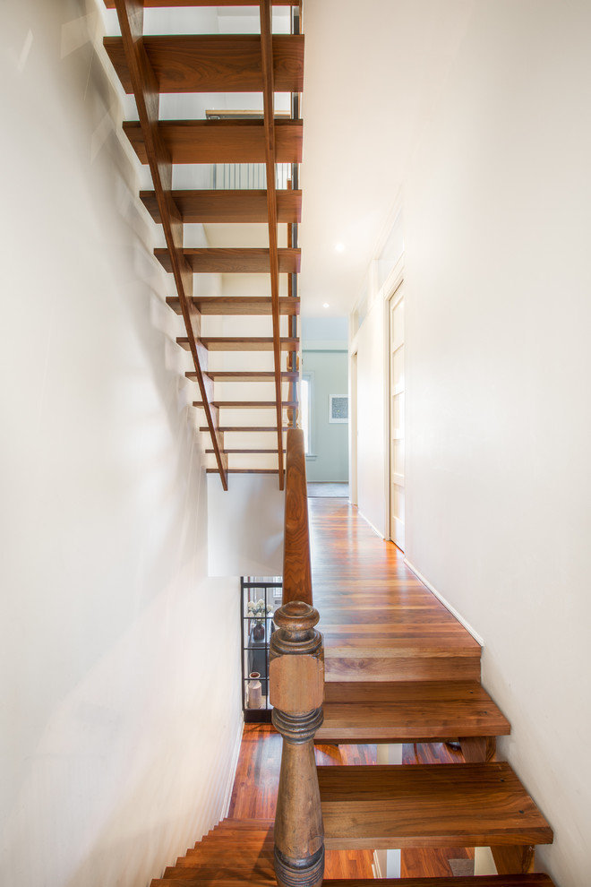 Пример оригинального дизайна: большая угловая лестница в стиле неоклассика (современная классика) с деревянными ступенями