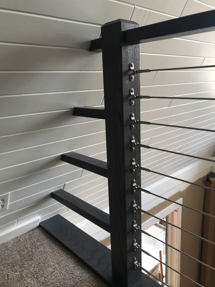 Aménagement d'un escalier droit contemporain de taille moyenne avec des marches en moquette, des contremarches en moquette et un garde-corps en câble.
