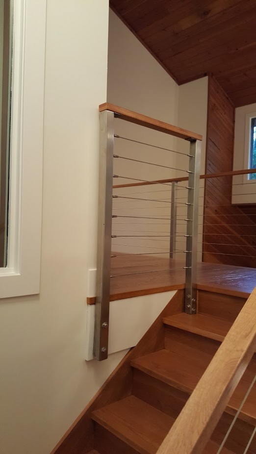 Свежая идея для дизайна: большая деревянная лестница в современном стиле с деревянными ступенями и перилами из тросов - отличное фото интерьера