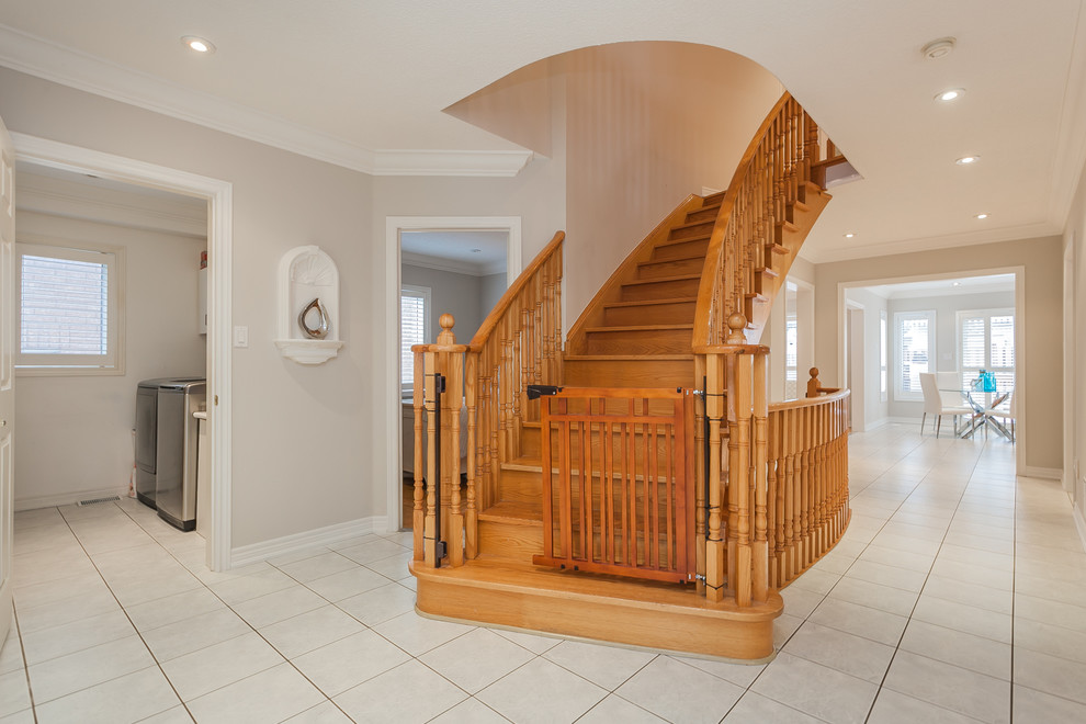 Idées déco pour un grand escalier courbe classique avec des marches en bois et des contremarches en bois.