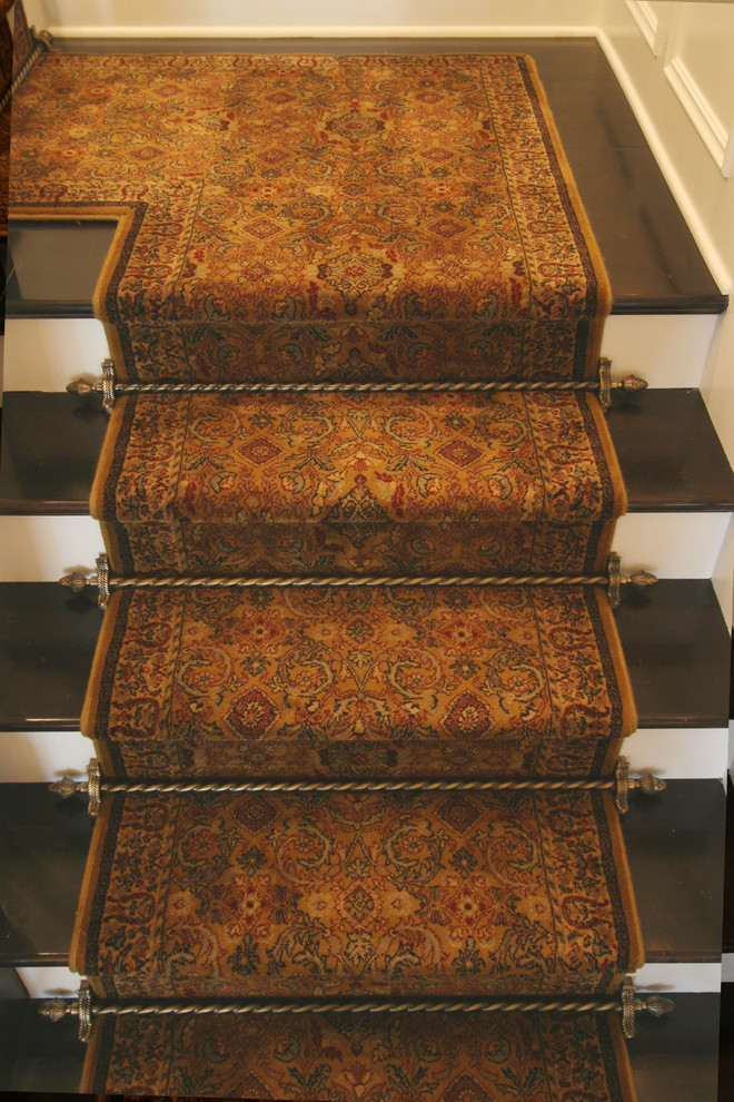 На фото: угловая деревянная лестница среднего размера в классическом стиле с ступенями с ковровым покрытием