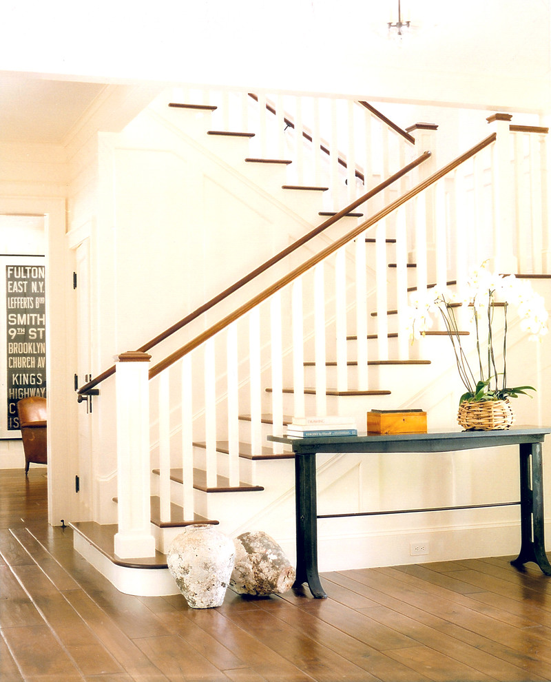 На фото: п-образная лестница в стиле кантри с деревянными ступенями и крашенными деревянными подступенками