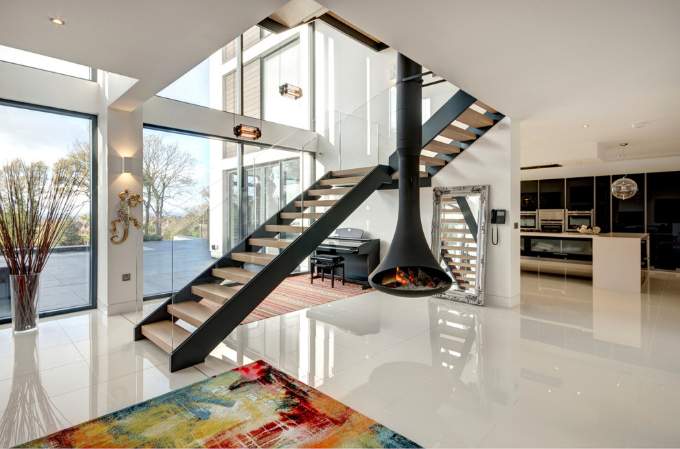 Cette photo montre un escalier tendance en L avec des marches en bois et un garde-corps en verre.