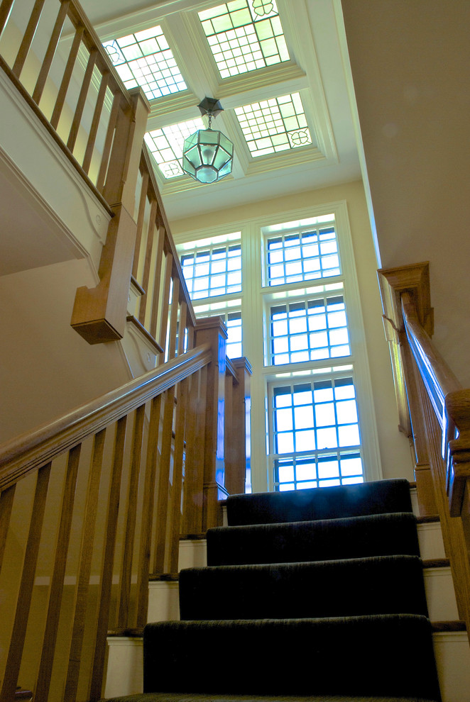 Large elegant wooden u-shaped staircase photo in Boston with painted risers