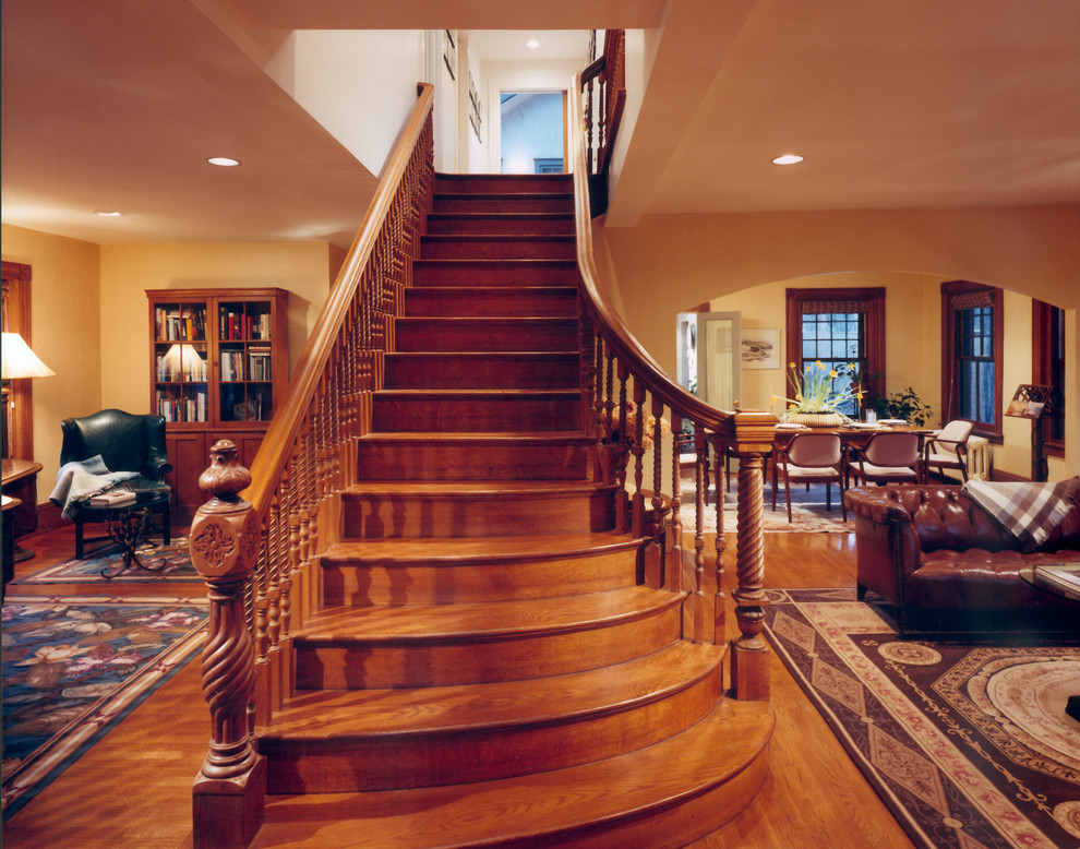 Idée de décoration pour un escalier courbe tradition de taille moyenne avec des marches en bois, des contremarches en bois et éclairage.