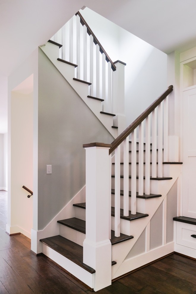 Diseño de escalera en U de estilo americano de tamaño medio con escalones de madera y contrahuellas de madera pintada