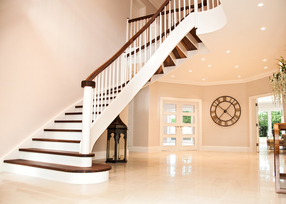 Пример оригинального дизайна: изогнутая деревянная лестница среднего размера в классическом стиле с деревянными ступенями и деревянными перилами