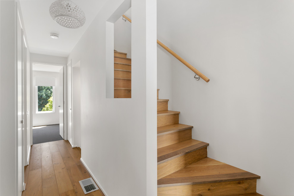 Источник вдохновения для домашнего уюта: угловая деревянная лестница среднего размера в современном стиле с деревянными ступенями и деревянными перилами