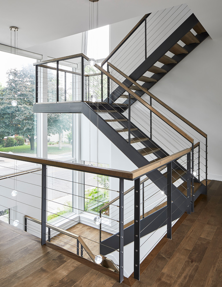 Modelo de escalera suspendida moderna grande sin contrahuella con escalones de madera y barandilla de madera