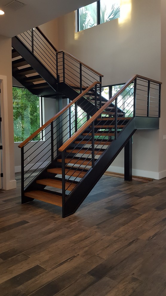 Идея дизайна: лестница на больцах в стиле модернизм с деревянными ступенями и металлическими перилами без подступенок