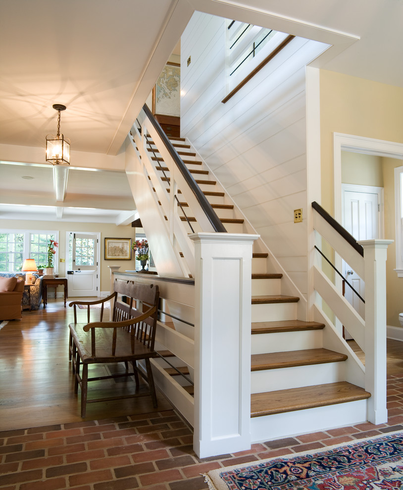 Photo of a classic wood straight staircase in Philadelphia with painted wood risers and feature lighting.