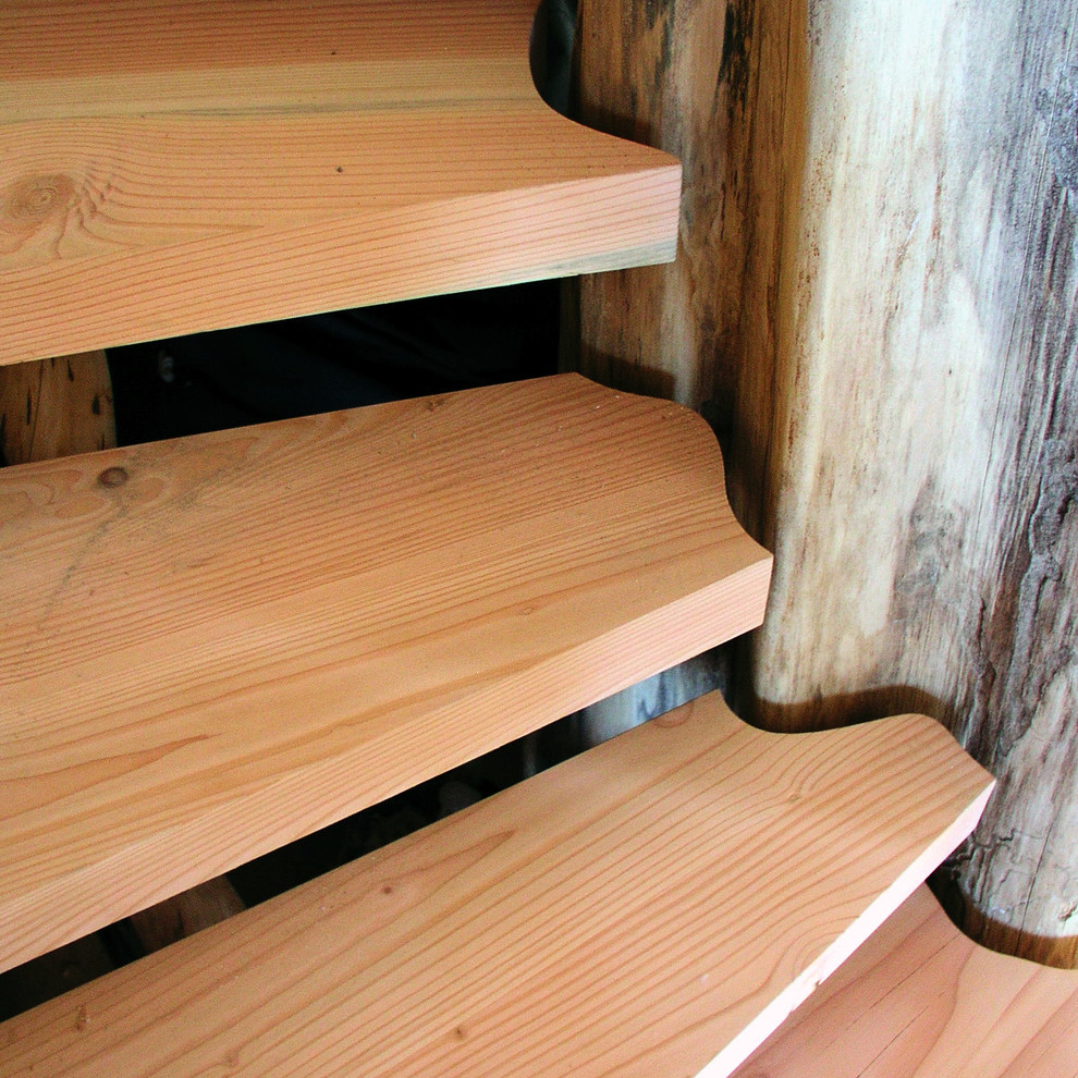 Photo of a rustic wood curved staircase in Portland with open risers.