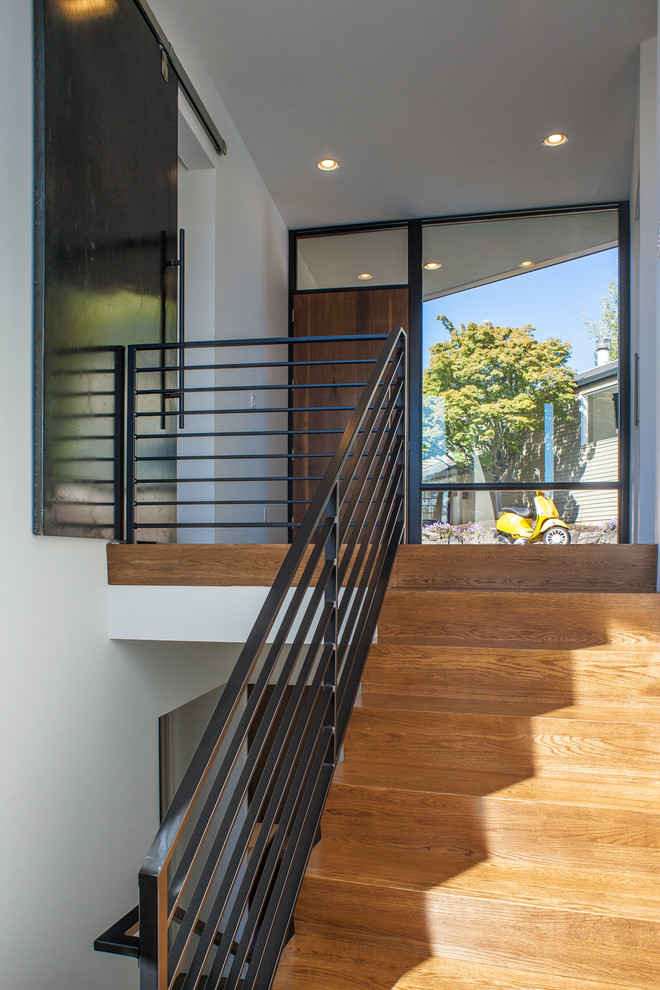 Aménagement d'un escalier moderne en U de taille moyenne avec des marches en bois, des contremarches en bois et un garde-corps en métal.